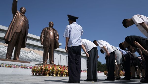 Cidadãos norte-coreanos prestam homenagem às estátuas dos líderes Kim Il-sung e Kim Jong-il, em Pyongyang - Sputnik Brasil