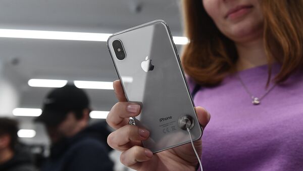 Compradora examina novo smartphone iPhone X em uma loja, em Moscou - Sputnik Brasil
