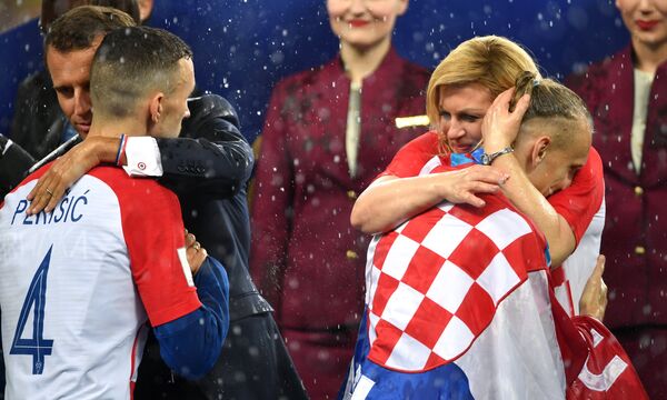 Presidentes de França e Croácia, Emmanuel Macron e Kolinda Grabar Kitarovic, abraçam jogadores croatas após final da Copa do Mundo - Sputnik Brasil