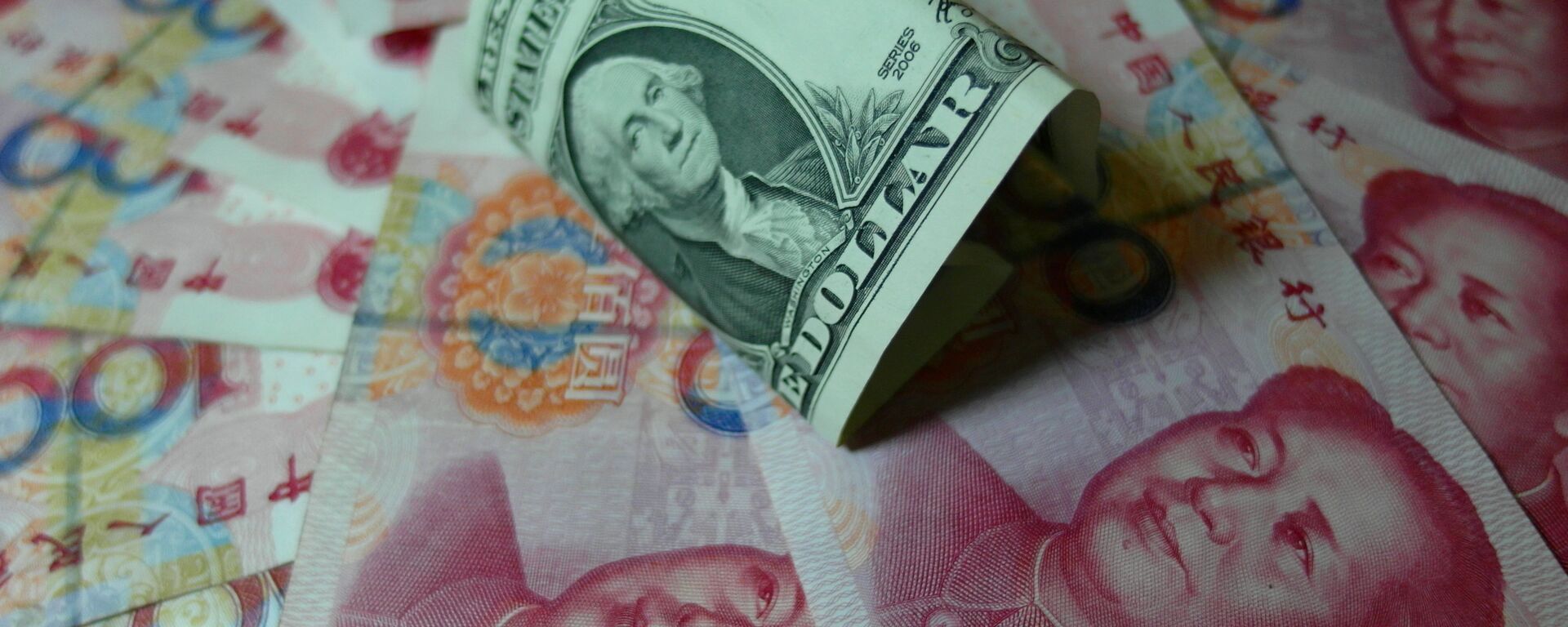 Notas yuan e dólares dos EUA são vistos em uma mesa em Yichang, província de Hubei, na China central em 14 de agosto de 2015 - Sputnik Brasil, 1920, 23.05.2022