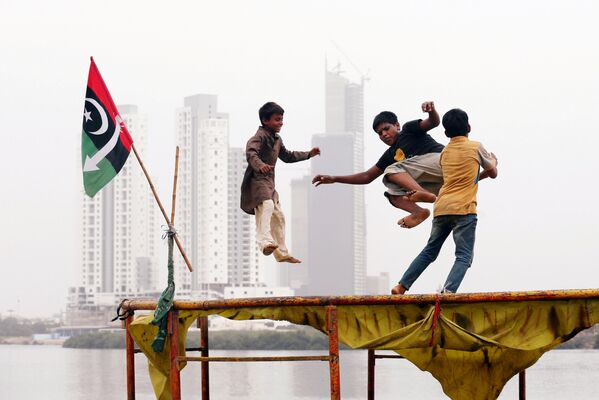 Crianças brincando em um trampolim em um bairro pobre de Karachi, Paquistão. - Sputnik Brasil