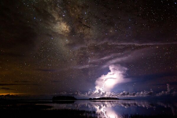 Tempestade sob a Via Láctea por Tianyuan Xiao. Nossa galáxia gloriosa paira sobre uma tempestade que ilumina o céu da Flórida. O fotógrafo mostra o excelente contraste entre os objetos estáveis (Via Láctea) e móveis (tempestade) no céu - Sputnik Brasil