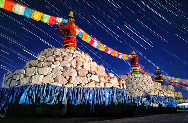 Estrelas sobre o sagrado mongol Ovoo – pedra sagrada da Mongólia por Qiqige Zhao. A imagem, tirada em uma noite de verão em Mingantu, mostra rastros das estrelas cadentes sobre os altares sagrados - Sputnik Brasil