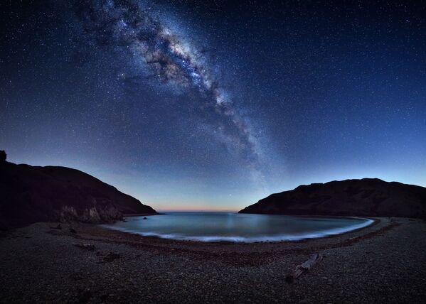 Cable Bay por Mark Gee. A encantada Via Láctea estende-se pelo céu noturno e é refletida por Cable Bay (Nova Zelândia). Para criar essa imagem panorâmica, o fotógrafo precisou de 42 fotos separadas - Sputnik Brasil