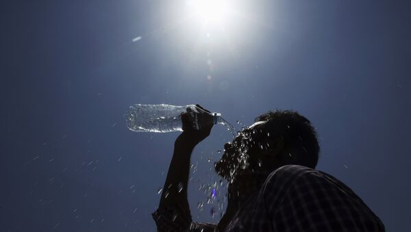 Homem derrama água no rosto durante um dia quente de verão em Hyderabad, Índia. - Sputnik Brasil
