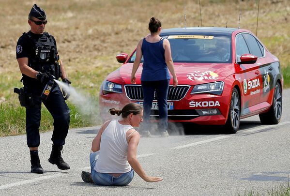 Policial usa spray de pimenta contra uma manifestante durante a competição Volta à França em bicicleta. - Sputnik Brasil