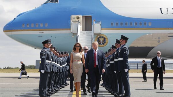 O presidente dos EUA, Donald Trump, e a primeira-dama Melania Trump, caminham no tapete em frente ao Força Aérea Um após descer em Londres. - Sputnik Brasil