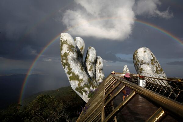 Arco-íris duplo aparece por cima da estrutura de mãos gigantes da Ponte Dourada em Ba Na Hills, na cidade vietnamita de Danang - Sputnik Brasil
