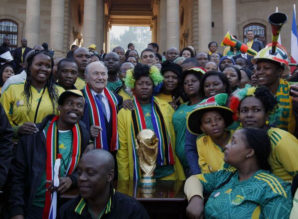 Funcionários públicos da África do Sul tiram foto coletiva com o presidente da FIFA, Joseph Blatter depois da entrega do troféu ao presidente interino africano Kgalema Motlanthe. Foto de 4 de junho de 2010. - Sputnik Brasil