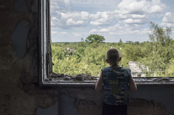 Menino dentro de um ginásio escolar devastado, que se tornou abrigo para refugiados, na cidade de Gorlovka, autoproclamada República Popular de Donetsk - Sputnik Brasil