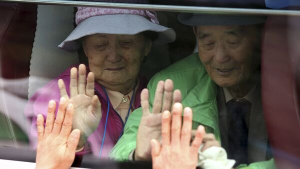 Sul-coreanos em um ônibus tocam a janela na tentativa de sentir as mãos de seus parentes norte-coreanos ao se despedirem após o Encontro da Reunião de Famílias Separadas no resort Diamond Mountain na Coreia do Norte. (Arquivo) - Sputnik Brasil