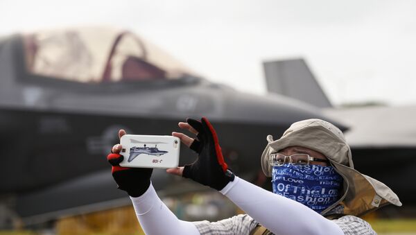 Visitante de um show aéreo em Singapura tirando selfie atrás de um caça F-35B da empresa norte-americana Lockheed Martin  - Sputnik Brasil