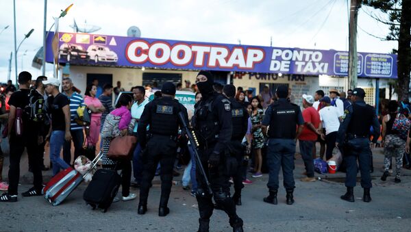 Policiais da tropa de choque conversam com pessoas da Venezuela depois de checar seus passaportes ou carteiras de identidade no controle de fronteira de Pacaraima, Roraima, Brasil - Sputnik Brasil
