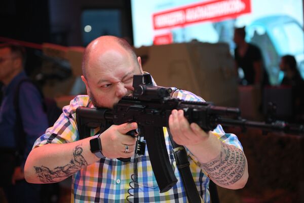Um visitante segurando o fuzil de assalto Ak-201 do consórcio Kalashnikov no Fórum EXÉRCITO 2018 - Sputnik Brasil