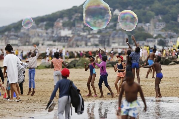 Crianças brincam na praia de Cabourg, na França, no âmbito de uma campanha “Esquecidos pelas Férias” destinada a providenciar lazer às crianças cujas famílias não podem se dar ao luxo de viajar - Sputnik Brasil