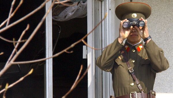 Soldado norte-coreano olha para o lado sul através de binóculos na vila fronteiriça de Panmunjom, na zona desmilitarizada que divide a Coreia do Norte e a Coreia do Sul, em 13 de abril de 2005 - Sputnik Brasil