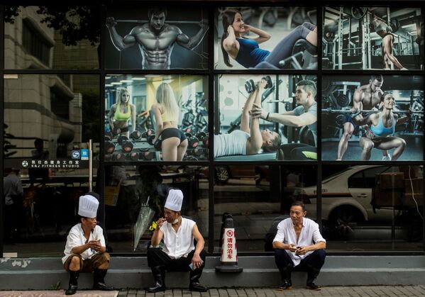 Três chefs de restaurante fazem uma pausa em frente a uma academia no centro de Xangai, em 4 de setembro de 2018 - Sputnik Brasil