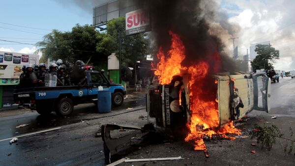 Policiais de choque passam por carro da polícia durante protesto contra o governo do presidente da Nicarágua, Daniel Ortega, na capital Manágua - Sputnik Brasil