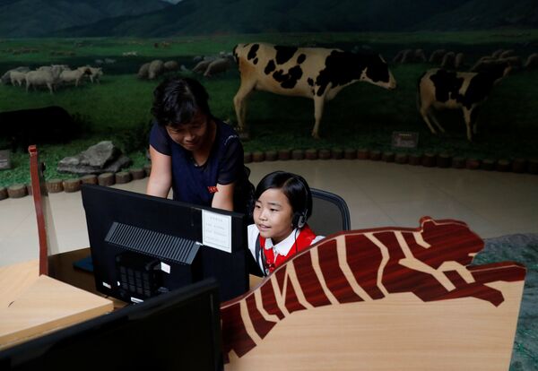 Uma menina ouve informação em um computador no Museu de História Natural em Pyongyang - Sputnik Brasil