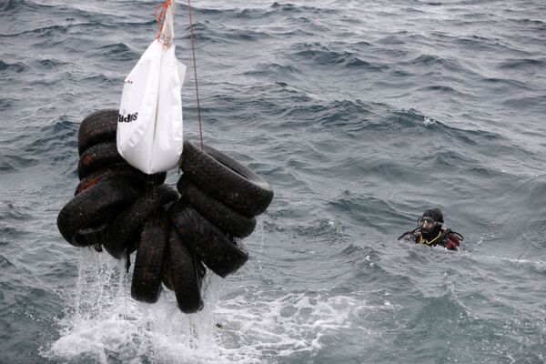 Tripulação de um navio levanta pneus de carros do mar perto da costa de Ática - Sputnik Brasil