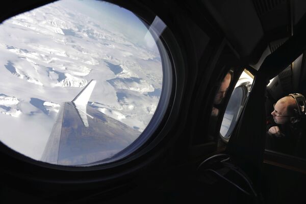 Diretor do programa Earth Science Flight da NASA, Eric Ianson, observa a camada de gelo enquanto sobrevoa a Groenlândia para medir o derretimento de gelo no país - Sputnik Brasil