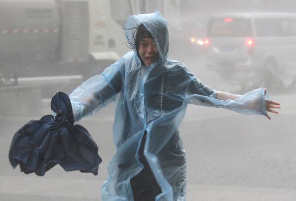 Mulher sob o aguaceiro provocado pelo tufão Shenzhen, na China - Sputnik Brasil
