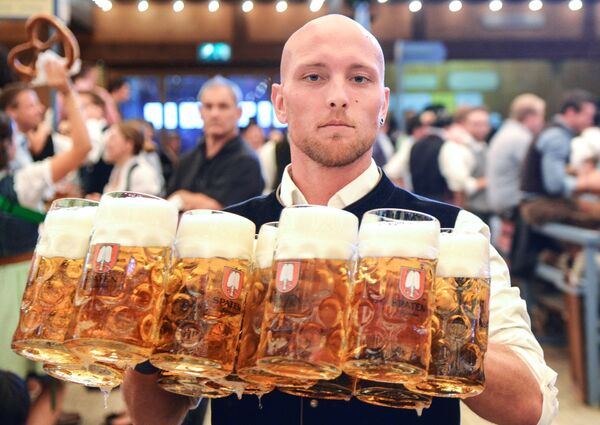 Garçom distribui canecas com cerveja durante a cerimônia de abertura do festival de cerveja Oktoberfest, em Munique, na Alemanha, em 22 de setembro de 2018 - Sputnik Brasil