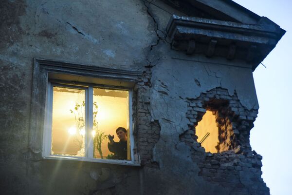 Morador de casa atingida por bombardeio em Donetsk - Sputnik Brasil