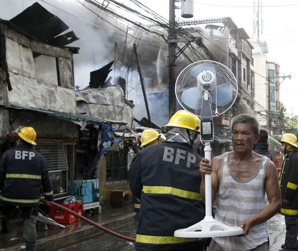Morador leva seus pertences após incêndio nas Filipinas - Sputnik Brasil