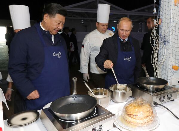 O líder chinês Xi Jinping e o presidente russo Vladimir Putin mostram suas habilidades culinárias durante o Fórum Econômico Oriental em Vladivostok, na Rússia, 11 de setembro de 2018 - Sputnik Brasil