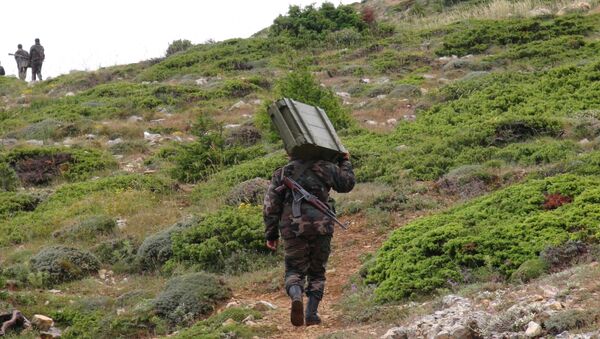Soldado do Exército sírio carregando armamento ao norte da província síria de Latakia - Sputnik Brasil
