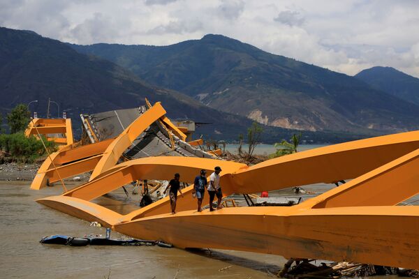 Pessoas andam por uma ponte destruída pelo terremoto, na cidade indonésia de Palu - Sputnik Brasil