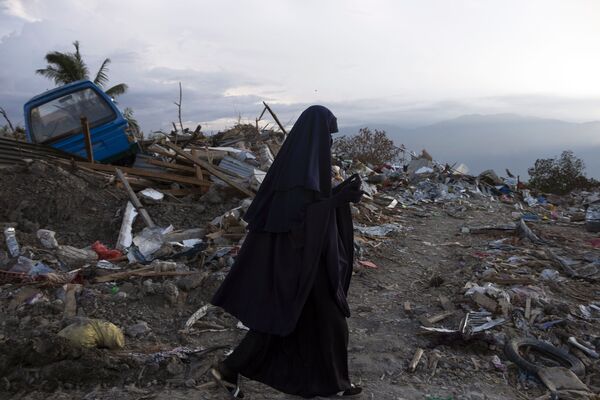 Mulher indonésia passa por zona destruída na aldeia de Petobo, em Palu, após o terremoto e tsunami que abalaram o local - Sputnik Brasil