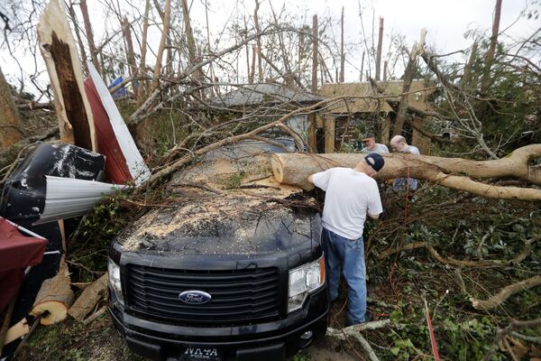 Pessoas serram árvores derrubadas pelo furacão Michael em Panama City, na Flórida - Sputnik Brasil