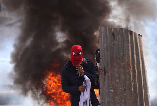 Manifestantes de Caxemira aparecem junto a pneus queimados durante os confrontos com policiais em Srinagar - Sputnik Brasil