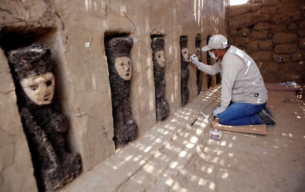 Arqueólogo escavando uma máscara de madeira da civilização Moche em Chan Chan, Peru - Sputnik Brasil