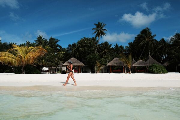 Moça caminhando em praia das ilhas Maldivas - Sputnik Brasil