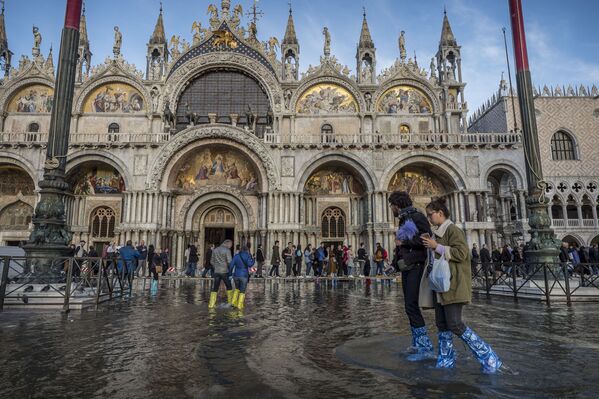 Pessoas na praça inundada de São Marcos, em Veneza (Itália), onde três quartos de seu centro histórico foram cobertos por água - Sputnik Brasil