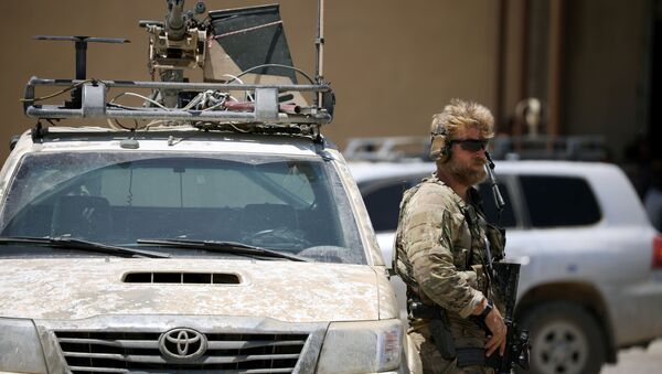 Soldados dos EUA segura uma arma enquanto mantém a guarda de um veículo blindado. A escolta faz parte da comitiva que acompanhou o enviado norte-americano para a coalizão internacional contra o Daesh, Brett McGurk, durante vistia à cidade de Tabqa, na Síria. - Sputnik Brasil