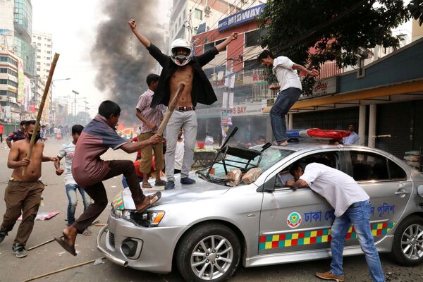 Ativistas do Partido Nacionalista de Bangladesh vandalizam um veículo policial durante confrontos em Daca, capital do país - Sputnik Brasil