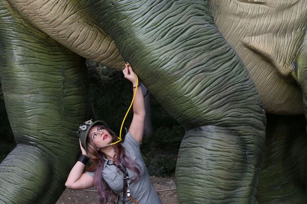 Cosplayer posa perto de uma figura de dinossauro em tamanho real, em uma exposição na Crimeia - Sputnik Brasil