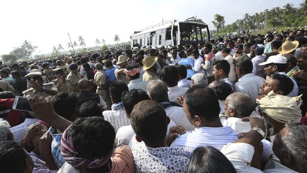 Uma multidão se aglomera em torno do ônibus recém retirado de um canal no distrito de Mandya, região sul da Índia. Ao menos 30 pessoas morreram, entre elas 5 crianças após o ônibus afundar nas águas do canal. - Sputnik Brasil