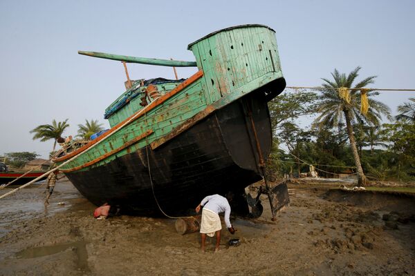 Trabalhadores reparando um barco na costa da ilha. - Sputnik Brasil