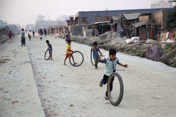 Crianças brincam com pneus na rua em Dhaka, Bangladesh - Sputnik Brasil