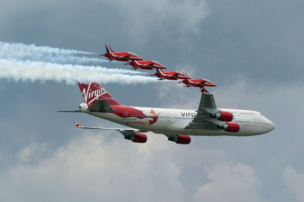 O Boeing 747-400 da empresa Virgin é acompanhado por um grupo de pilotagem da Força Aérea Real britânica Red Arrows (Estrelas Vermelhas) - Sputnik Brasil