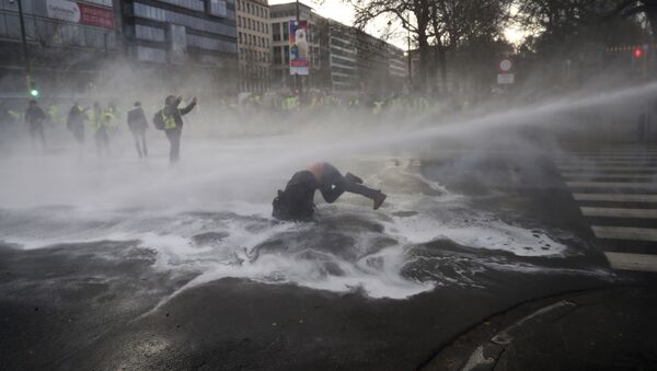 Manifestante é atingido por canhão de água durante protesto dos 'coletes amarelos' em Bruxelas. - Sputnik Brasil