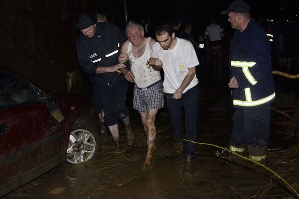 Socorristas ajudam a evacuar uma pessoa idosa de uma área alagada em Tbilisi - Sputnik Brasil