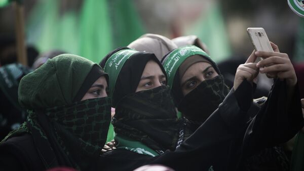 Mulheres tiram selfie em manifestação de comemoração do aniversário da fundação do Hamas em Gaza. - Sputnik Brasil