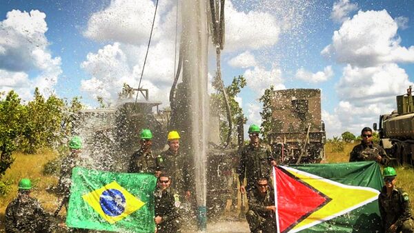 Militares brasileiros posam com bandeiras do Brasil e da Guiana diante de poço artesiano. - Sputnik Brasil