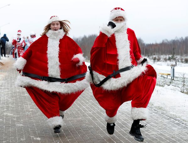 Bielorrussos vestidos de Papai Noel participam de corrida em torno de um lago em Minsk, Bielorrússia, 15 de dezembro de 2018 - Sputnik Brasil